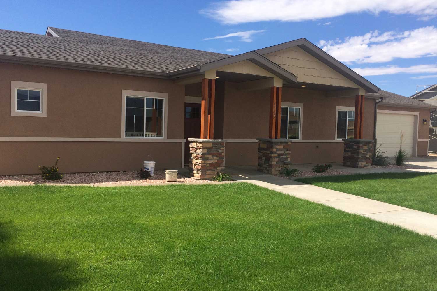 exterior of the new house with the front door and sidewalk in view