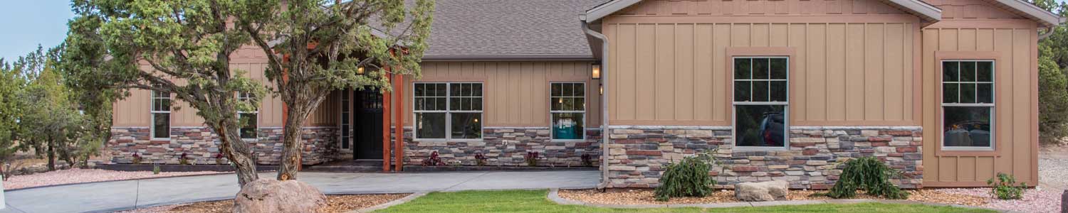 exterior of new custom home front porch entry, two car garage and paved driveway