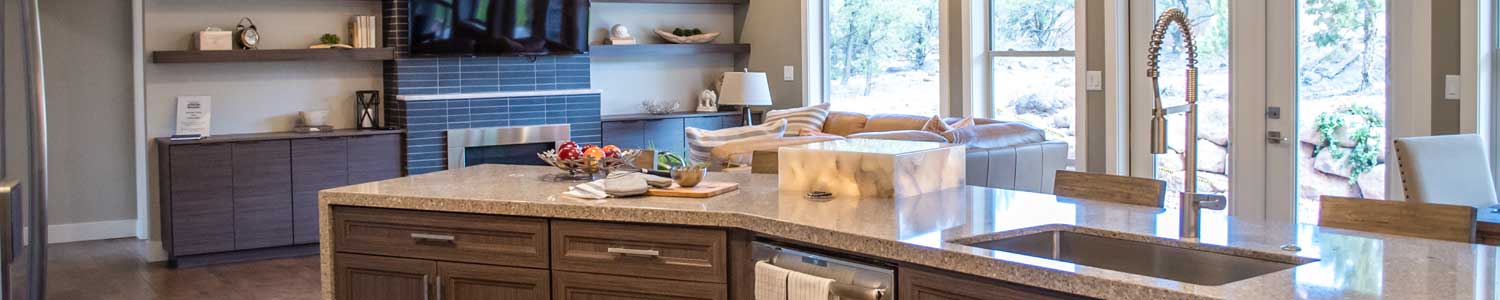 open floor plan kitchen counter area and living room looking out into backyard through sliding glass doors