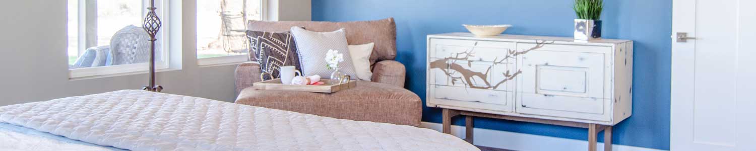 guest bedroom with bureau and loveseat next to large windows