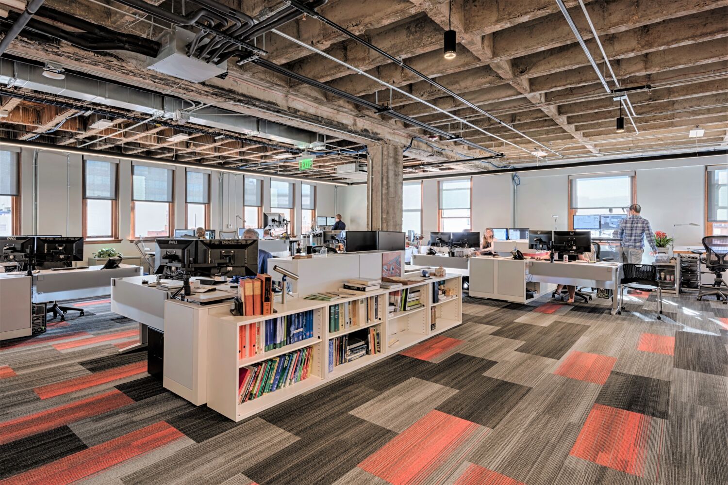 open-concept office with workstations and exposed industrial ceiling
