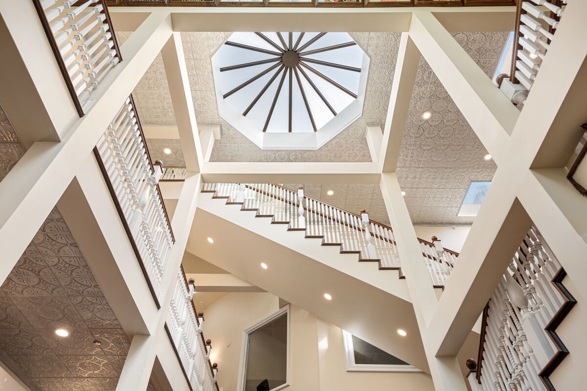 Interior view of the Stanley Chocolate Factory atrium looking upward at multiple stair levels and a large octagonal skylight with decorative detailing.