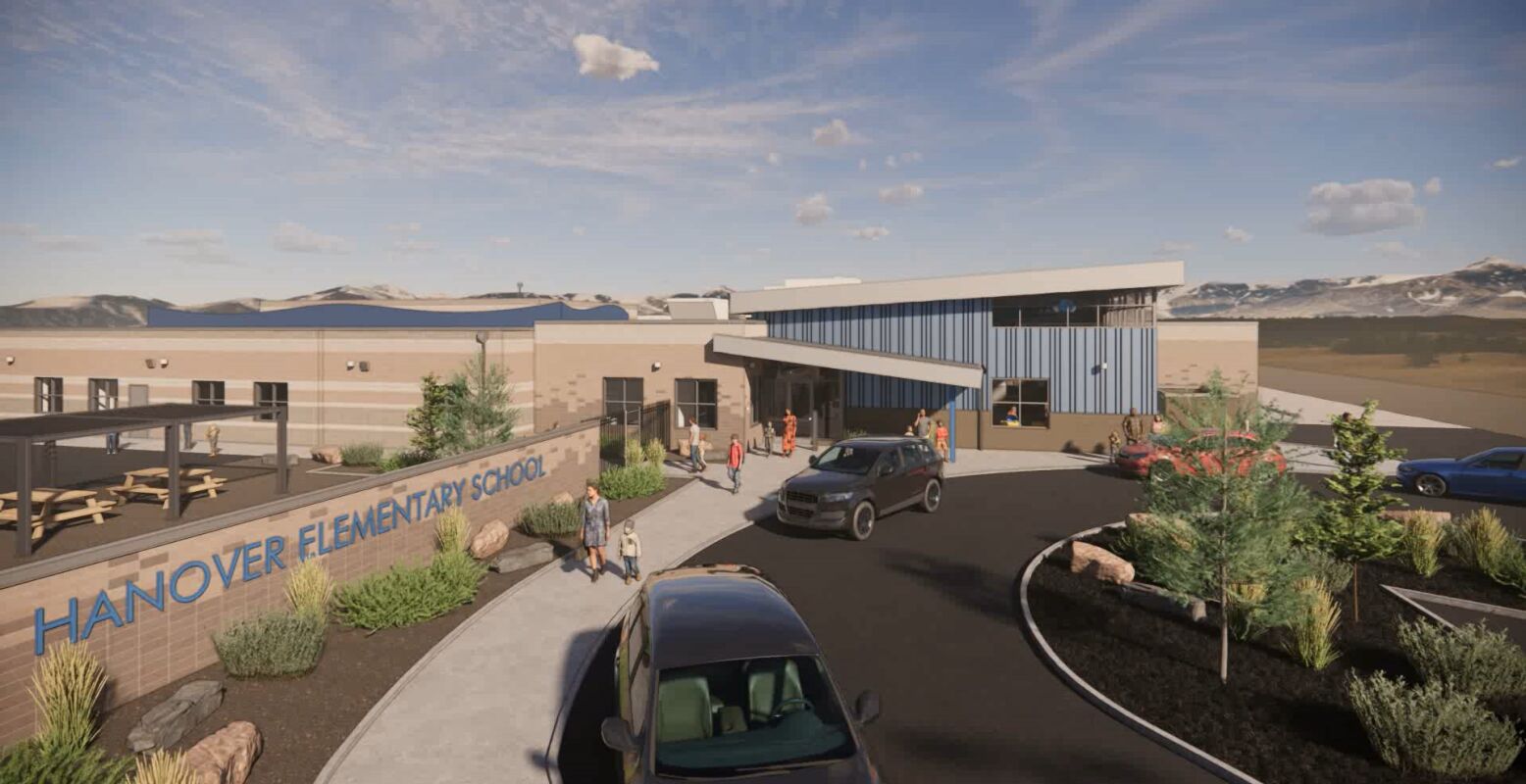 Exterior rendering of an elementary school building with a sloping metal roof, blue and beige façade materials, covered entry canopy, landscaped planting beds, asphalt drop‑off loop, and mountains visible in the background under a partly cloudy sky.