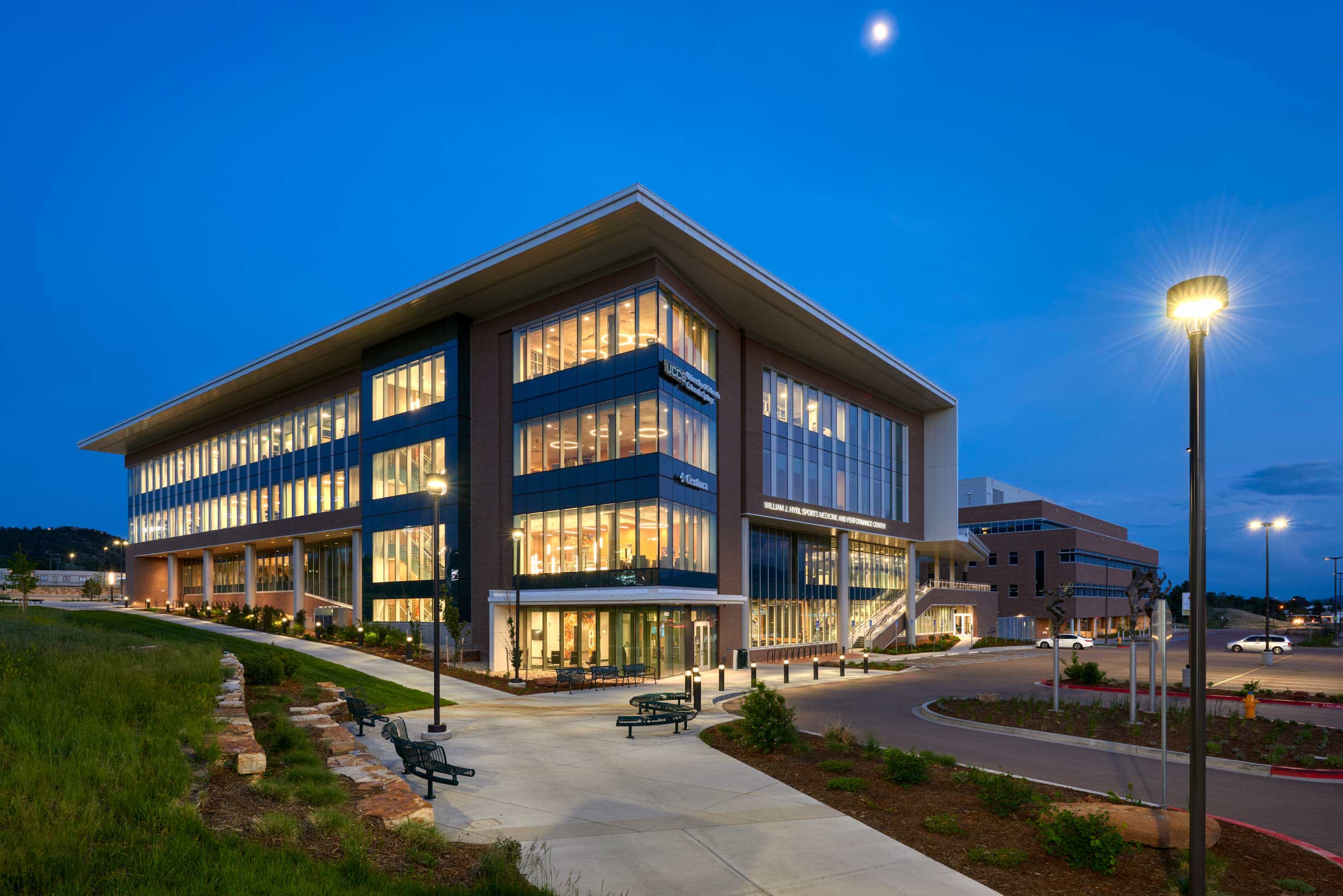 Interior view of the Hybl Center, showcasing a spacious, modern design with an open floor plan, large windows, and a mix of seating areas. The space is filled with natural light and features sleek architectural elements that promote collaboration and learning.