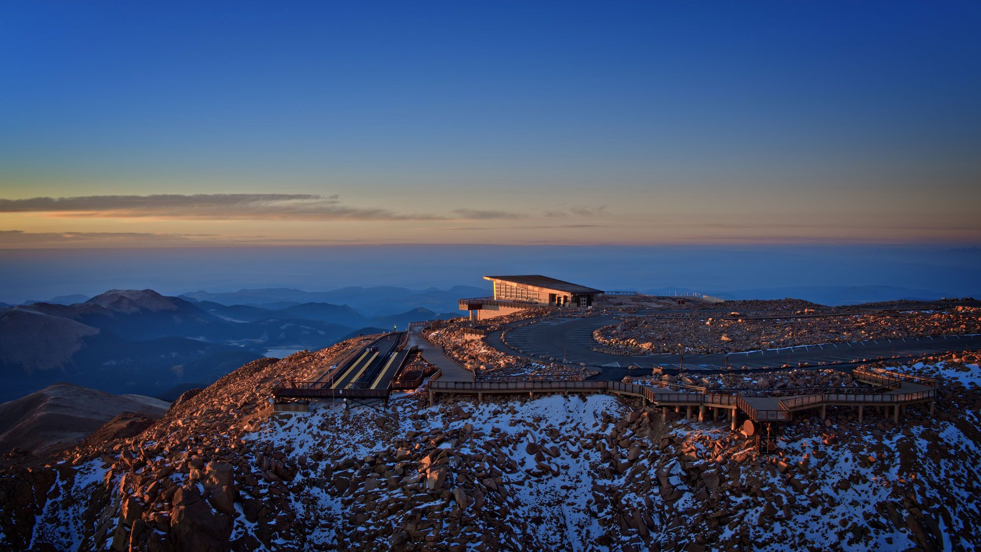 Aerial view of the Pikes Peak Summit, showcasing the modern summit complex surrounded by breathtaking mountain landscapes.